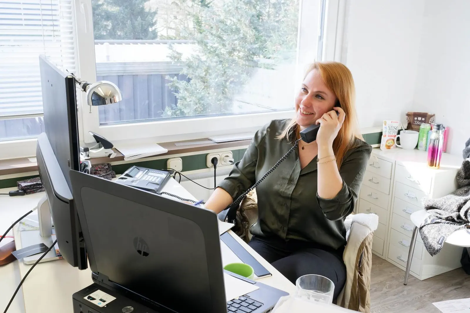 Mitarbeiterin des Architektenhauses am Telefon im Büro